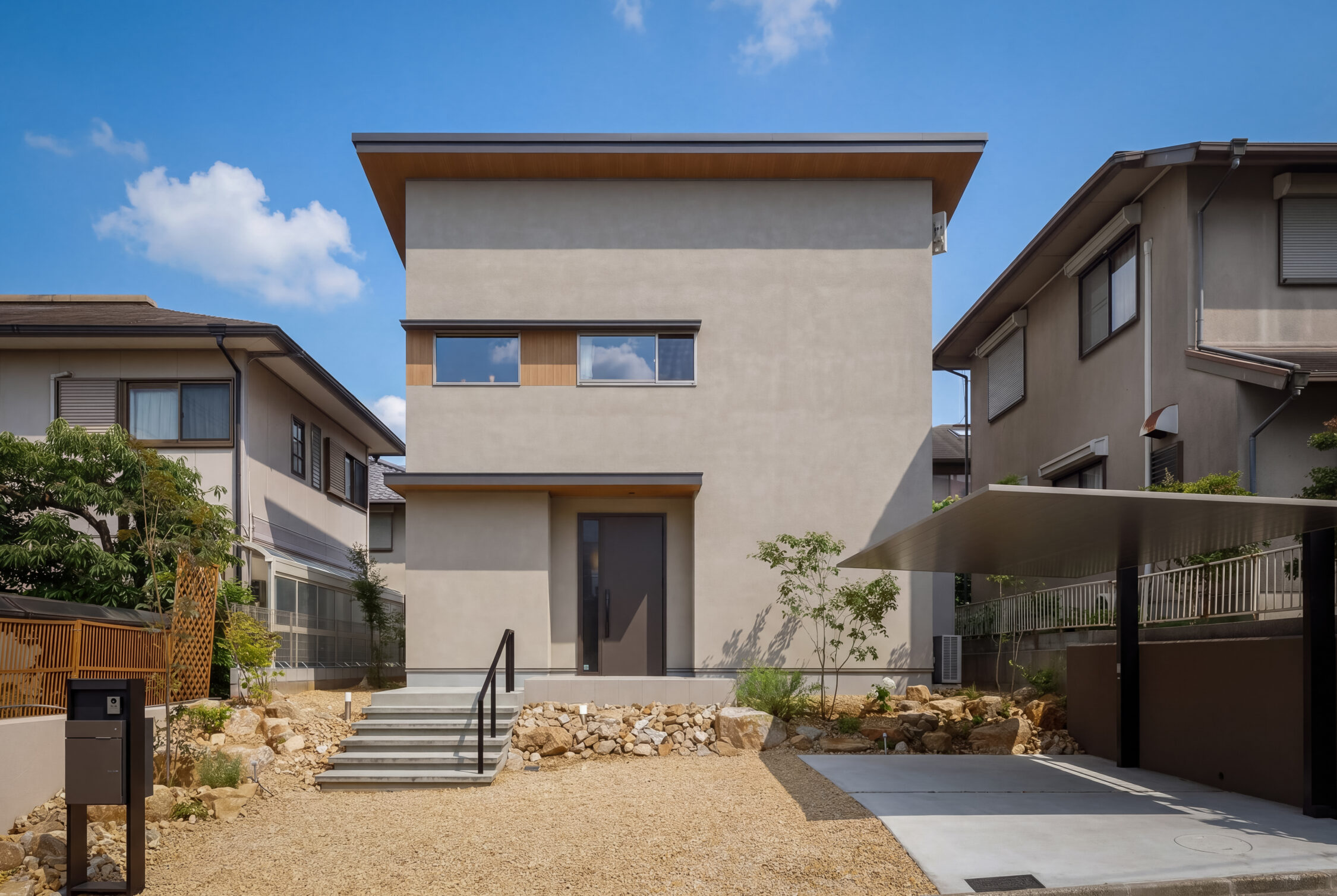奈良市・新築注文住宅。ベージュの塗り壁と木調アクセントの外観